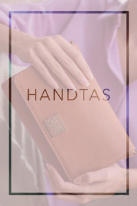 Twee handen houden een bruine handtas vast. Roze Overlay.